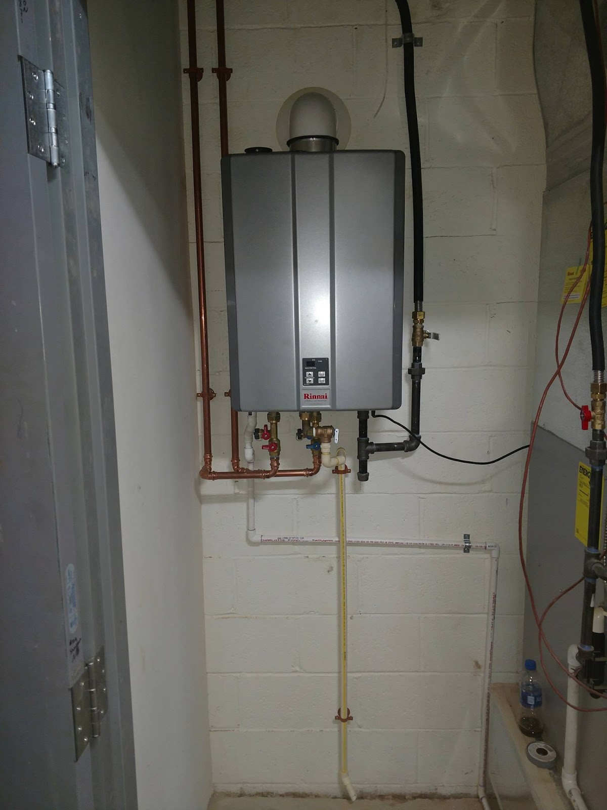 Rinnai tankless water heater installed with copper supply lines in a basement mechanical room